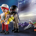 Two toy figures in a cityscape setting with a motorcycle and urban elements.