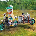 Child playing with a toy motorcycle and sidecar in a natural setting