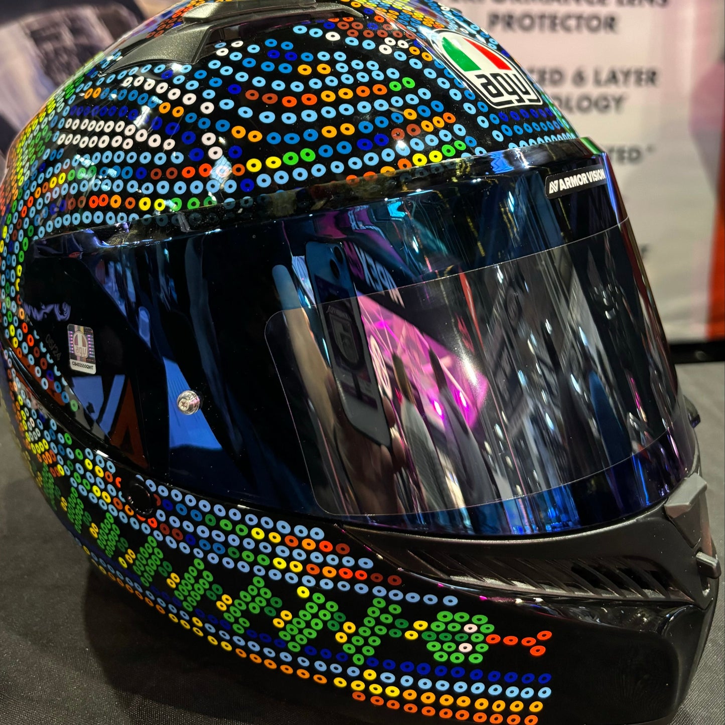 Colorful helmet with sequin embellishments on a reflective surface