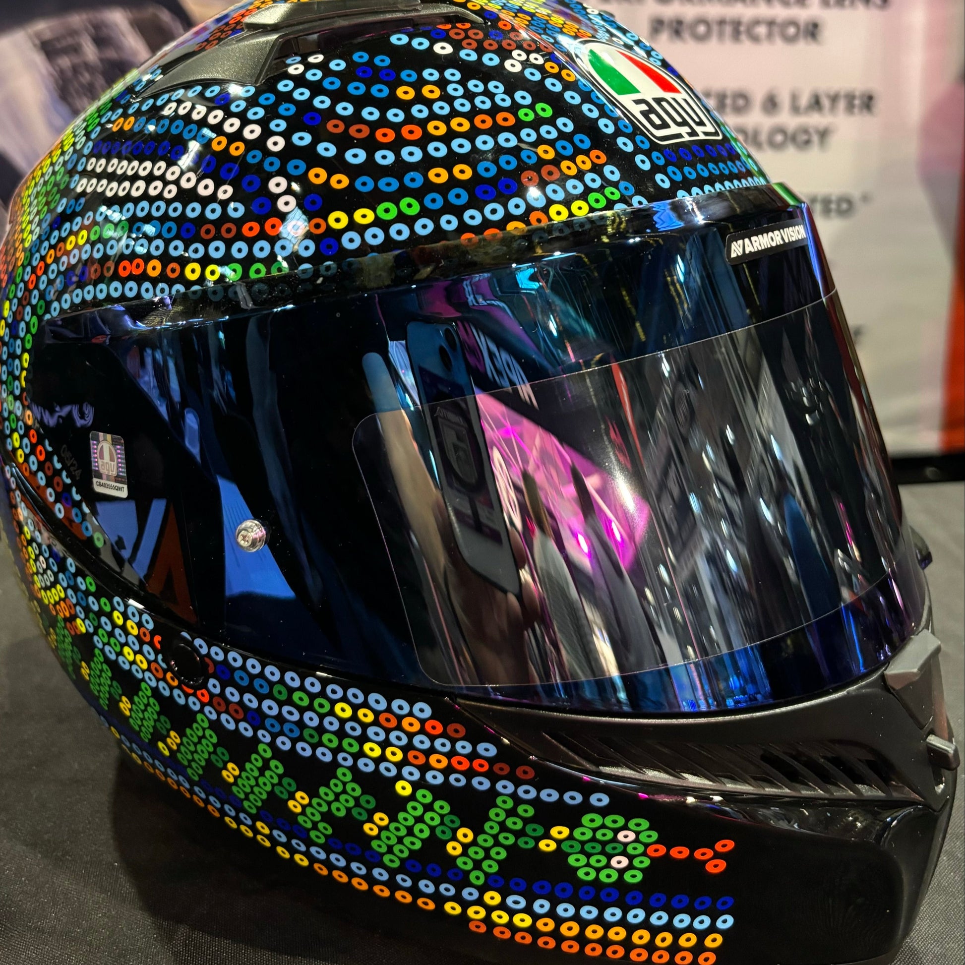 Colorful helmet with sequin embellishments on a reflective surface