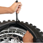 Person installing tire chains on a vehicle tire with a tool from Unit Tyre
