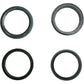 Four black rubber oil seals on a white background