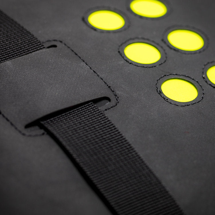 Black bag with yellow circular patterns and a strap